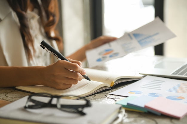 Las mujeres de negocios están revisando la tabla de desempeño de la compañía.