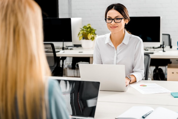 mujeres de negocios en el lugar de trabajo con computadoras portátiles en la oficina