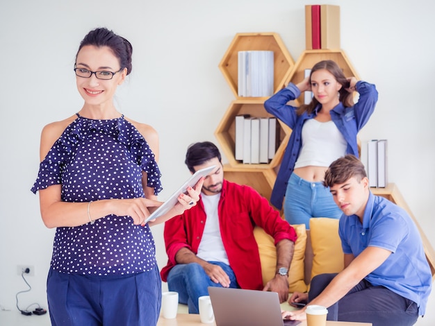 Las mujeres de negocios se paran y posan en el trabajo