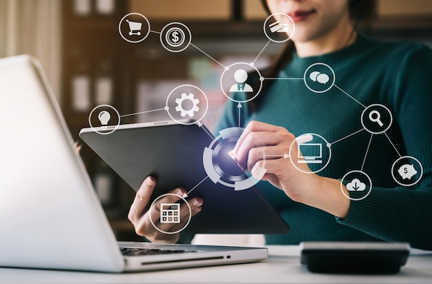 Foto mujeres de negocios que trabajan con una computadora portátil y una tableta digital en la oficina con medios de marketing digital en un icono virtual