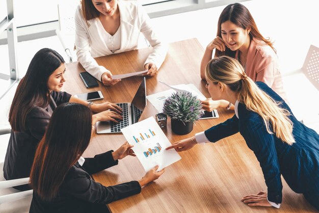 Mujeres de negocios en una reunión con computadora portátil en la mesa