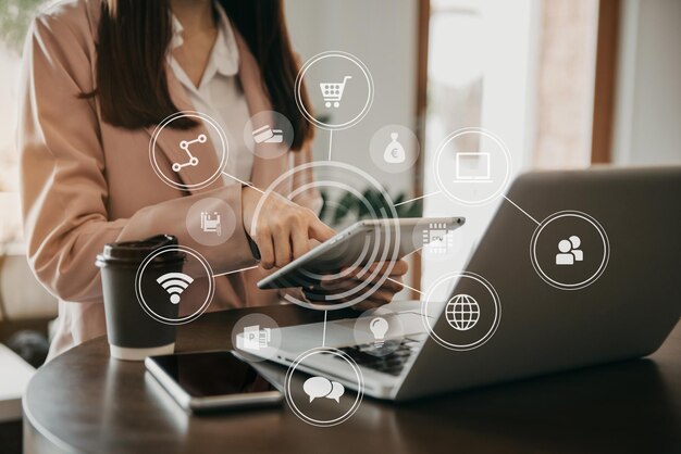 Las mujeres de negocios trabajan a mano con una tableta y una computadora portátil con un teléfono inteligente en el escritorio de la oficina