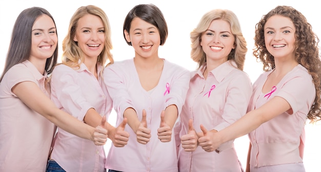 Mujeres participantes en cáncer de mama gesticular pulgares arriba.