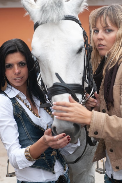 Foto mujeres en el picadero junto a las caballerizas esperando salir a trotar en su caballo