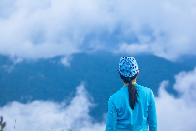 Foto mujeres de pie mirando la niebla en la montaña.