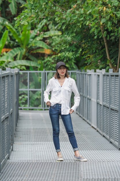 Mujeres de pie posando en un puente de hierro en el parque