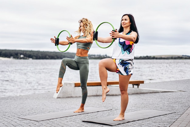 las mujeres practican ejercicios de yoga en una colchoneta con un círculo deportivo especial