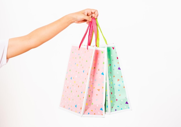 Mujeres de primer plano sosteniendo la mano colorida bolsa de compras multicolor muchos paquetes aislados en fondo blanco mujer sostiene en la mano blanco claro vacío papel de artesanía bolsa de regalo concepto de día de compras