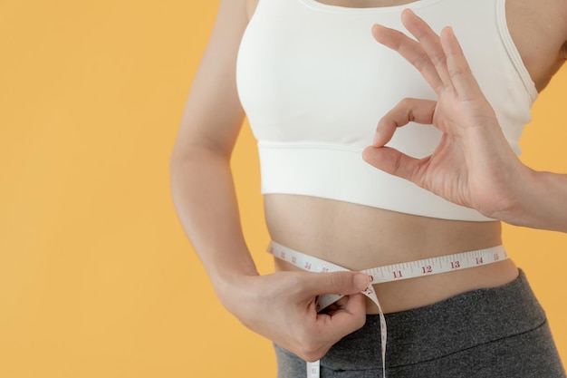 Las mujeres que muestran los resultados de la dieta Las mujeres de forma hermosa tienen un tamaño de cintura reducido después de someterse a un corso de pérdida de peso no pueden usar jeans debido al ejercicio de rutinas de control de equilibrio de pérdida de peso