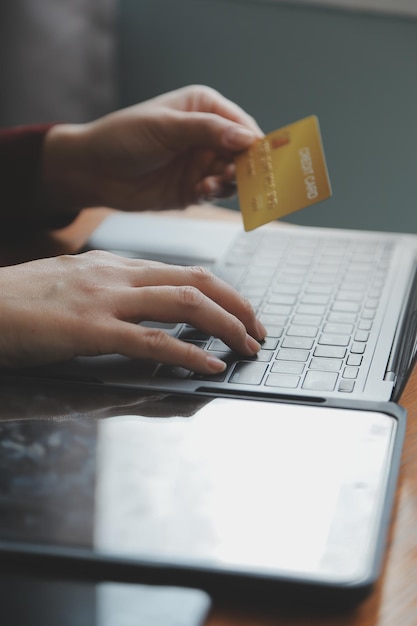 Mujeres que tienen tarjeta de crédito y usan teléfonos inteligentes en casa Compras en línea Tienda de banca por Internet Pago en línea Gastar dinero Pago de comercio electrónico en el concepto de tarjeta de crédito de la tienda