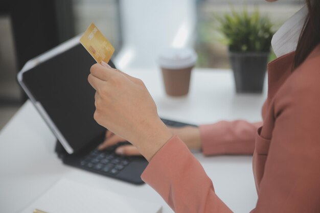 Mujeres que tienen tarjeta de crédito y usan teléfonos inteligentes en casa Compras en línea Tienda de banca por Internet Pago en línea Gastar dinero Pago de comercio electrónico en el concepto de tarjeta de crédito de la tienda