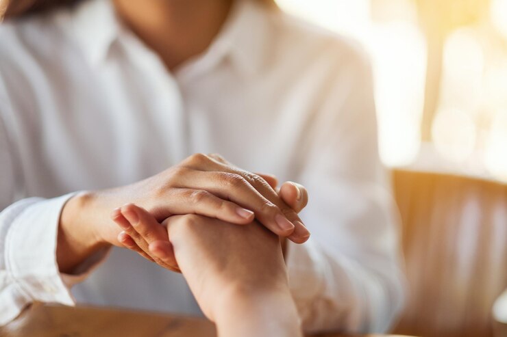 Foto mujeres que se toman de la mano por consuelo y simpatía.
