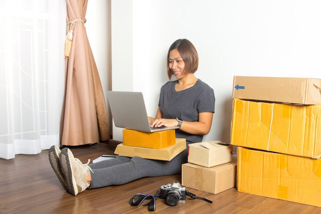 Mujeres que trabajan con ordenador portátil desde casa en piso de madera.