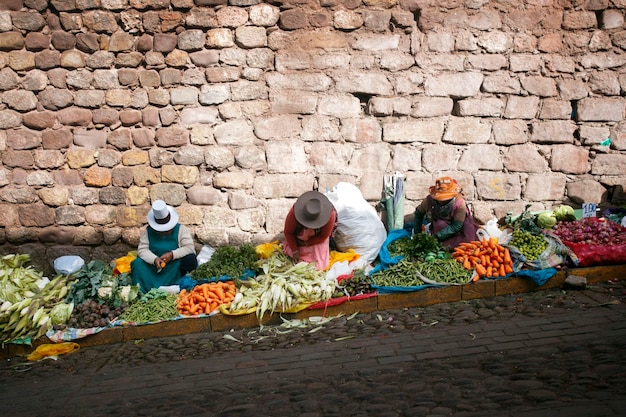 Mujeres que venden maíz y otras verduras orgánicas en las calles de la ciudad de Cusco en Perú