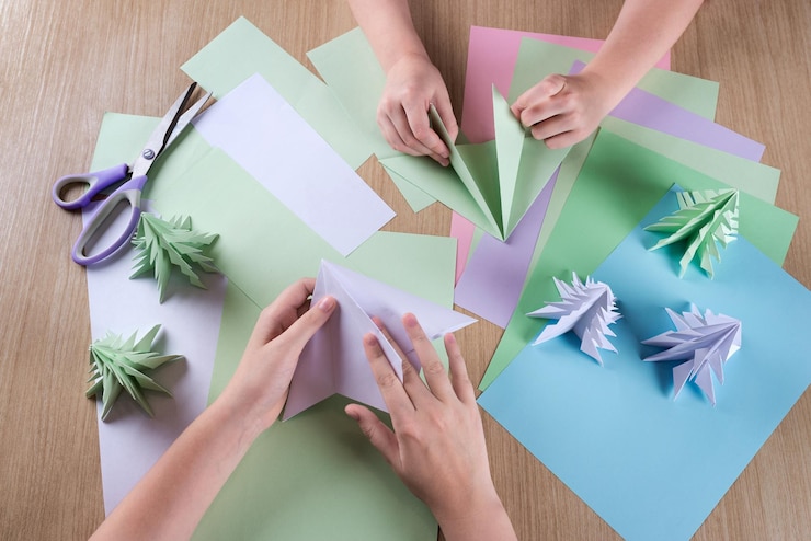 Foto mujeres recortadas haciendo origami en la mesa
