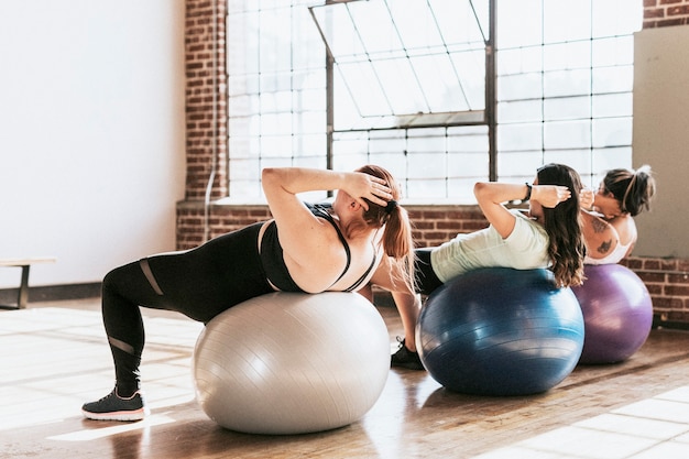 Mujeres sanas con pelota de fitness para un entrenamiento de abdominales