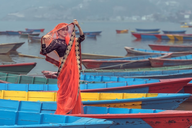 Las mujeres en sari de pie en el barco, el lago Phewa, la ciudad de Pokhara, Nepal