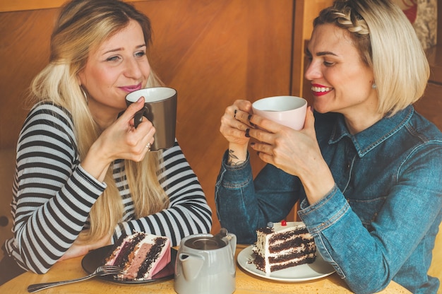 Mujeres sentadas en un café y beber un té caliente