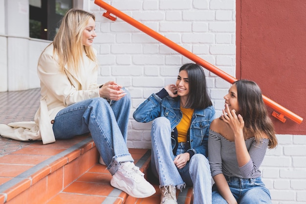 Foto mujeres sentadas en la pared