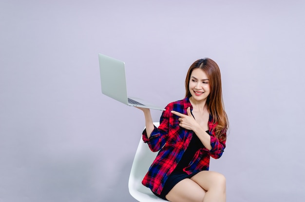 Mujeres sentadas y usando laptop felizmente en el trabajo