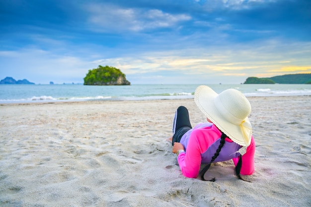 Las mujeres con sombreros duermen en el mar de la playa.