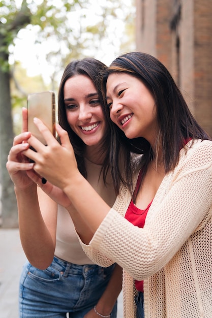 Mujeres sonriendo felices mirando contenido en el teléfono