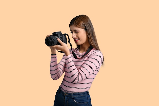 mujeres sonriendo y tomando fotos sobre fondo naranja modelo indio paquistaní