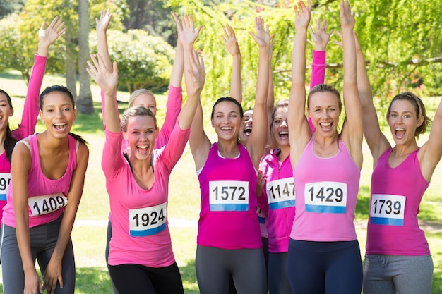 Foto mujeres sonrientes corriendo por la concientización sobre el cáncer de mama