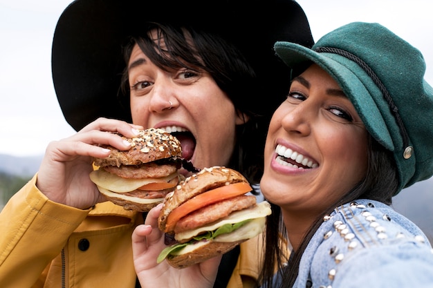 Foto mujeres sonrientes con deliciosas hamburguesas