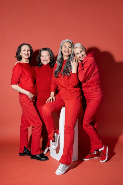 Foto mujeres sonrientes de tiro completo posando juntas