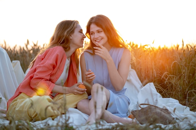 Foto mujeres sonrientes de tiro completo sentados juntos