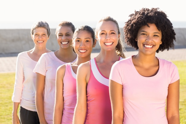 Mujeres sonrientes vistiendo rosa para el cáncer de mama