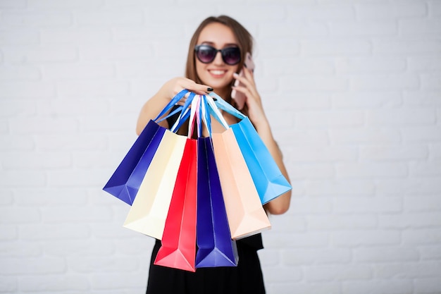 Mujeres sosteniendo bolsas de colores sobre fondo de luz en las vacaciones del viernes negro