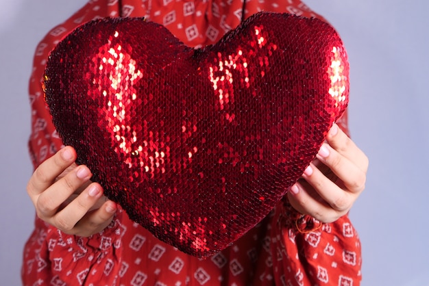 mujeres sosteniendo corazón rojo en las manos