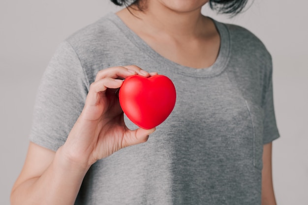 Mujeres sosteniendo y mostrando un corazón rojo.