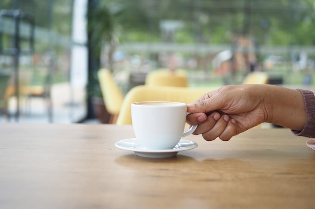 Mujeres sosteniendo una taza de café contra el fondo del café