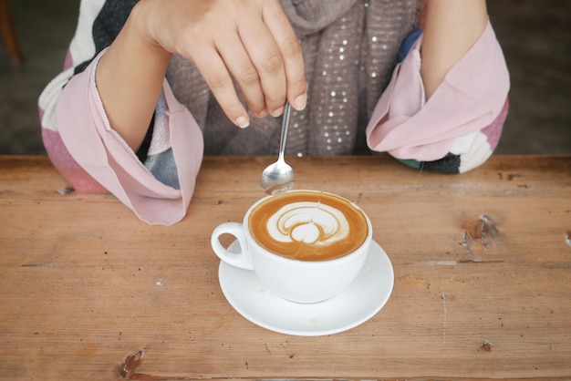 Mujeres sosteniendo una taza de café en la mesa