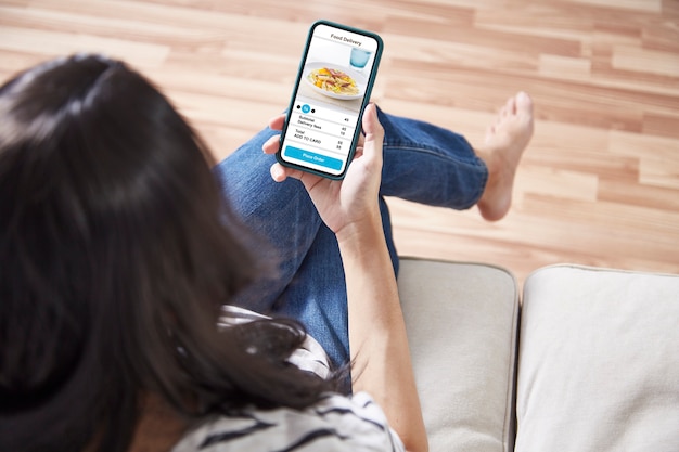 Mujeres sosteniendo teléfono con comida de entrega de aplicaciones en línea