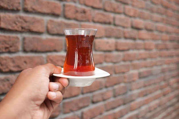 mujeres sosteniendo un vaso de té tradicional con té turco