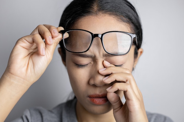 Las mujeres sostienen los anteojos y sufren dolor en los ojos.