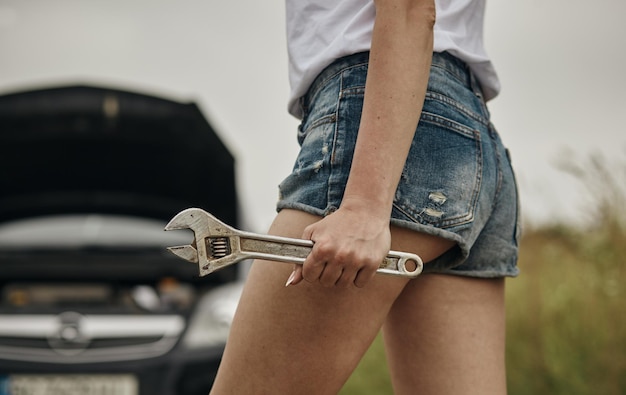 Mujeres spection Ella abrió el capó Coche roto en el costado Ver motores que están dañados o no