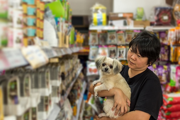 Las mujeres y su perro compran en la tienda de mascotas