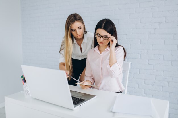 Mujeres con tableta en la computadora portátil