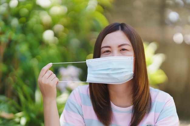 Mujeres tailandesas con máscaras con desenfoque de fondo natural. Concepto de prevención de enfermedades.