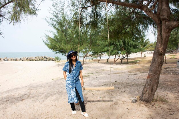 Las mujeres tailandesas se relajan y juegan columpios para tomar fotos en la mañana en la playa de Saeng Chan en Rayong Tailandia