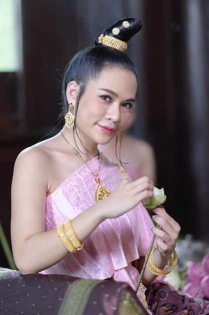 Las mujeres tailandesas en traje tradicional tailandés están decorando flores.