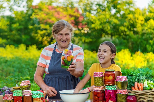 Mujeres con tarro de verduras en conserva para el invierno madre e hija Enfoque selectivo