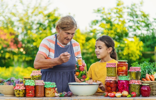 Mujeres con tarro de verduras en conserva para el invierno madre e hija Enfoque selectivo