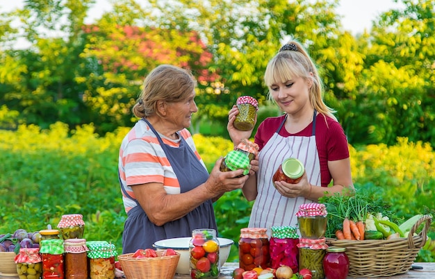 Mujeres con tarro de verduras en conserva para el invierno madre e hija Enfoque selectivo