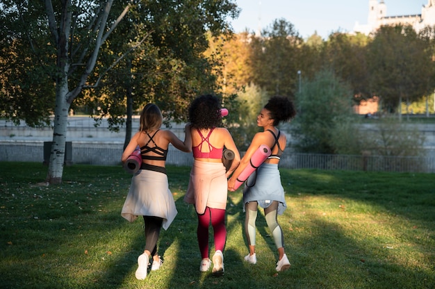 Mujeres de tiro completo con colchonetas de yoga